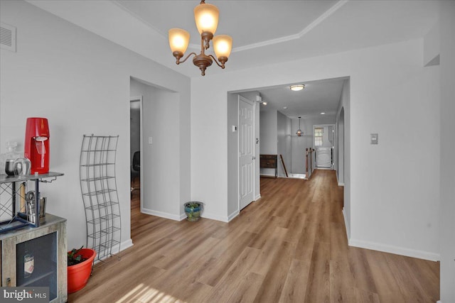 unfurnished dining area featuring wood finished floors, baseboards, and a chandelier