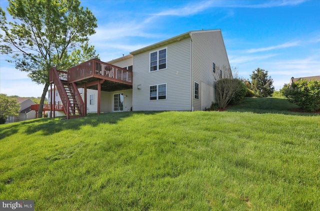 rear view of house featuring a wooden deck, a lawn, and stairway