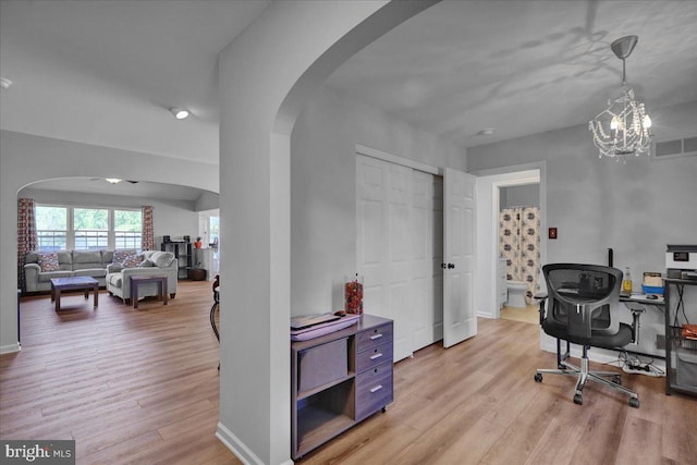 office featuring arched walkways, light wood finished floors, a chandelier, and baseboards