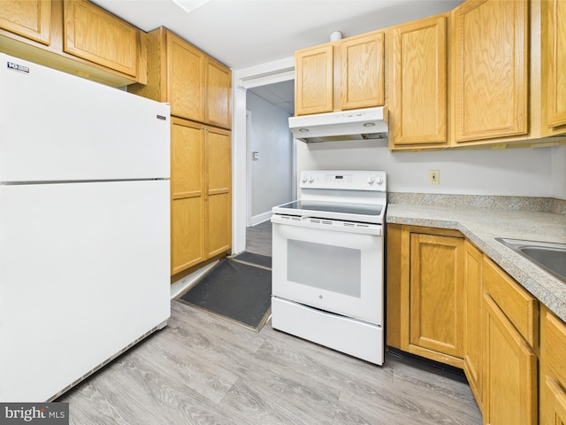 kitchen with white appliances, under cabinet range hood, light countertops, light wood-type flooring, and a sink