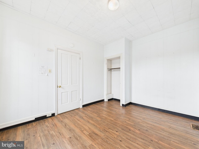 unfurnished bedroom with wood finished floors and baseboards