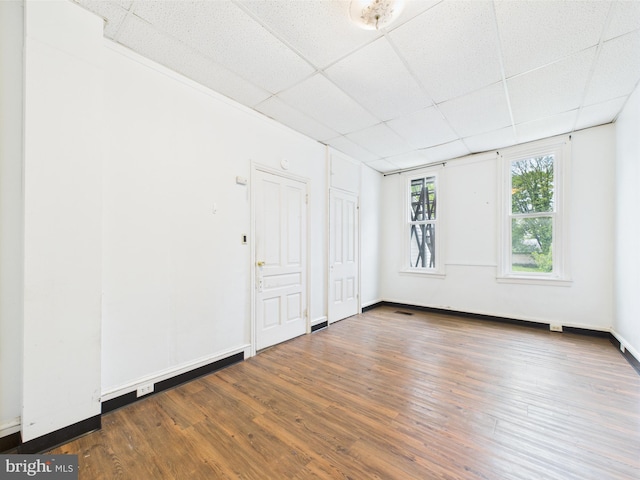 empty room featuring a paneled ceiling and wood finished floors