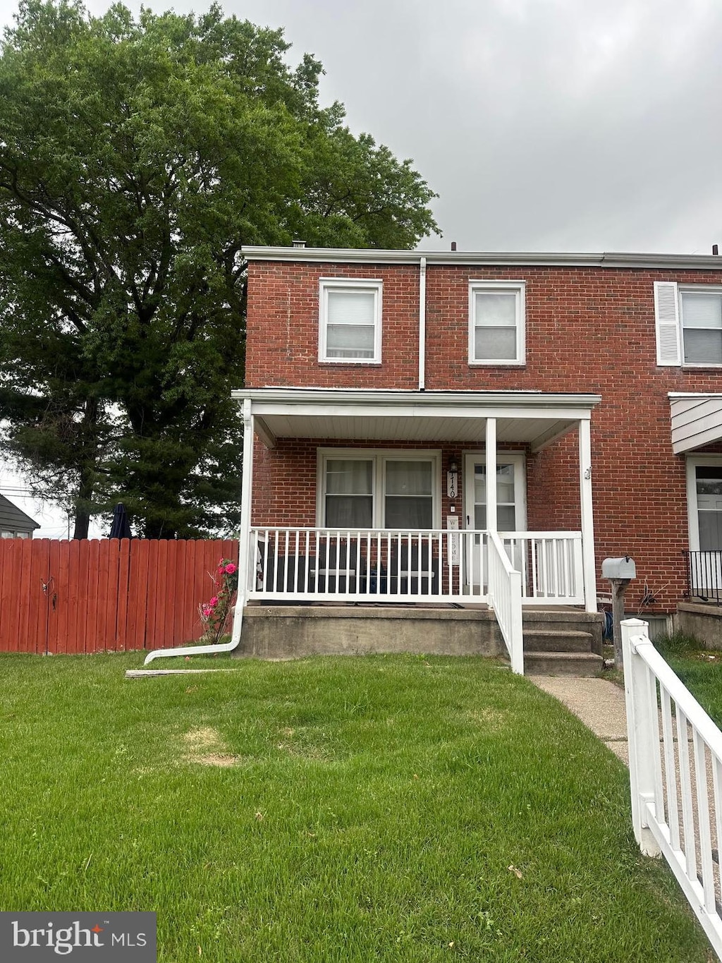 view of front facade featuring brick siding and covered porch