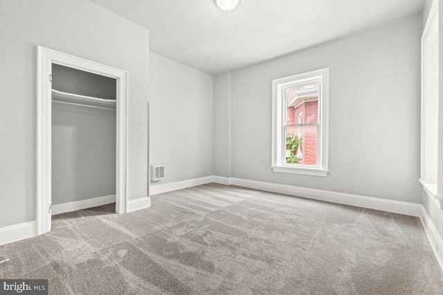 unfurnished bedroom featuring a closet, visible vents, baseboards, and carpet floors
