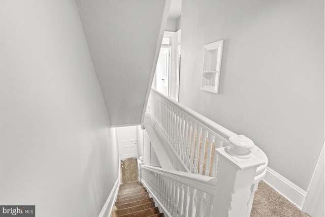 stairs with wood finished floors and baseboards