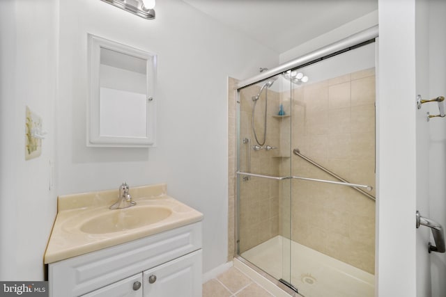 full bath featuring a stall shower, vanity, and tile patterned flooring