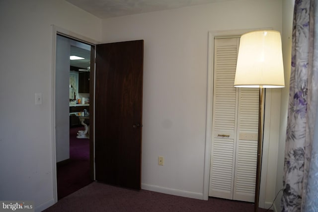 unfurnished bedroom with carpet, a closet, and baseboards