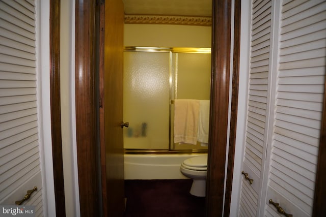 full bathroom featuring toilet, a closet, and enclosed tub / shower combo