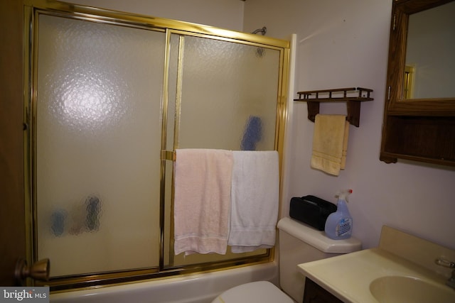 full bath featuring toilet, vanity, and combined bath / shower with glass door