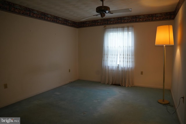 empty room with carpet, baseboards, and a ceiling fan