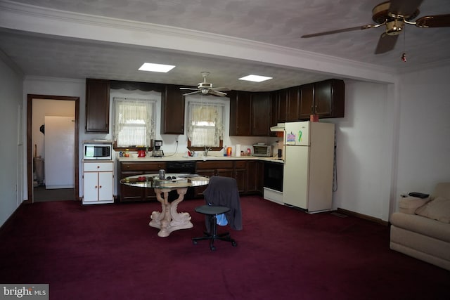 kitchen featuring stainless steel microwave, freestanding refrigerator, ornamental molding, and a ceiling fan