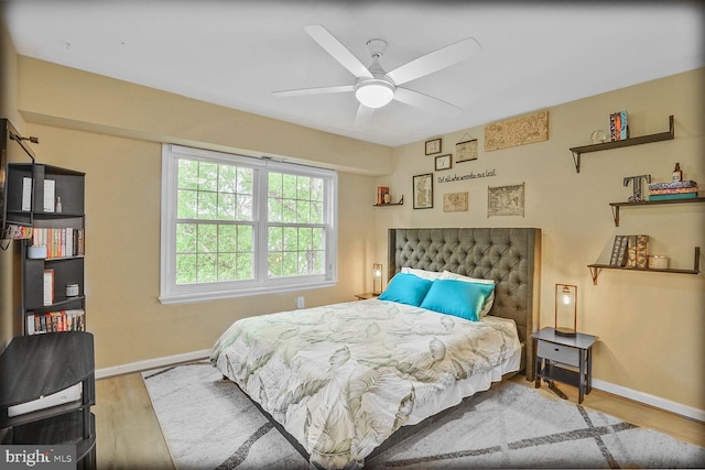 bedroom with wood finished floors, baseboards, and a ceiling fan