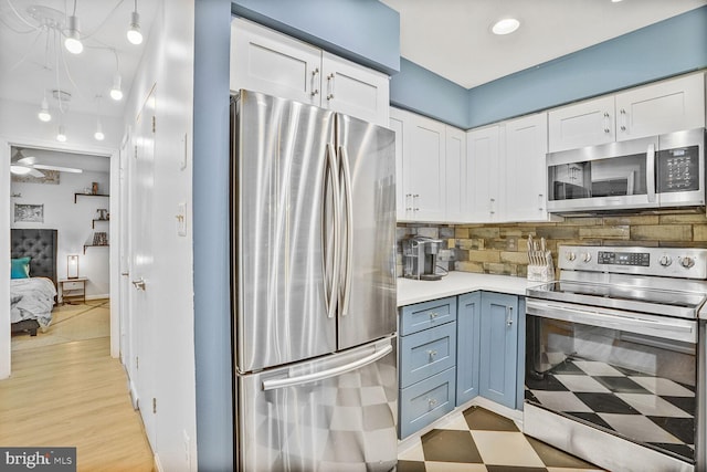 kitchen with appliances with stainless steel finishes, white cabinetry, light countertops, tasteful backsplash, and light floors