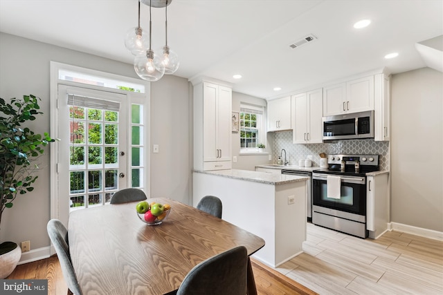 4829 27th Rd S, Arlington, VA 22206 - kitchen with stainless steel appliances, white cabinets, light wood-style floors, a sink, and recessed lighting