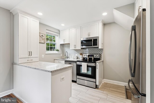 4829 27th Rd S, Arlington, VA 22206 - kitchen featuring appliances with stainless steel finishes, white cabinetry, decorative backsplash, light stone countertops, and a sink