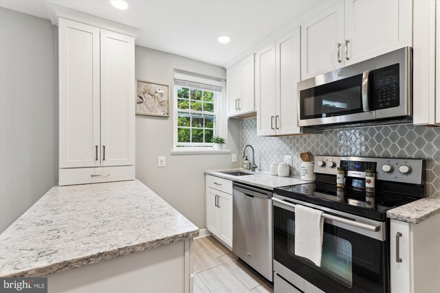 4829 27th Rd S, Arlington, VA 22206 - kitchen with stainless steel appliances, a sink, tasteful backsplash, white cabinets, and light stone counters