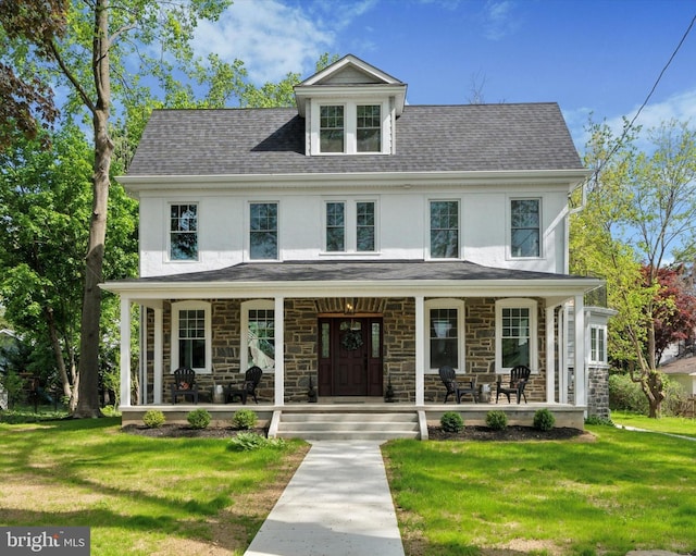 view of front facade with a porch, stucco siding, and a front yard