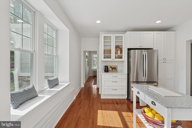 kitchen with freestanding refrigerator, white cabinets, glass insert cabinets, dark wood-style floors, and recessed lighting