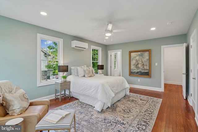 bedroom featuring a wall mounted AC, baseboards, wood finished floors, recessed lighting, and ceiling fan