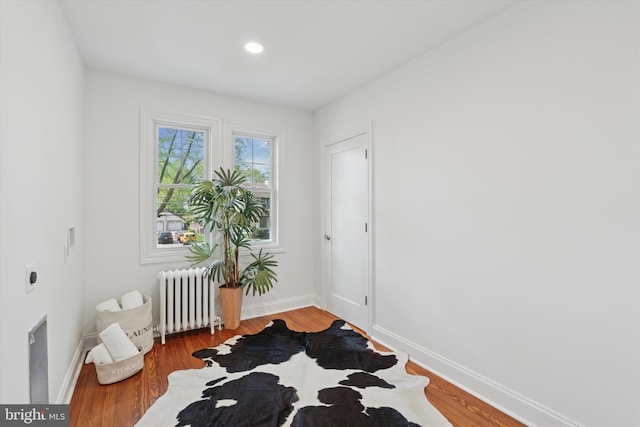 entryway featuring radiator heating unit, baseboards, wood finished floors, and recessed lighting