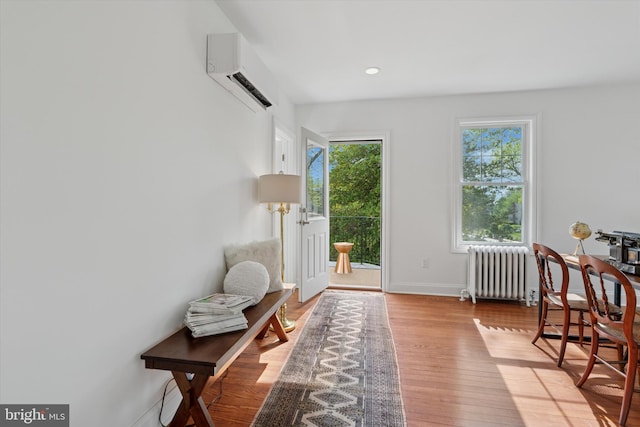 entryway featuring radiator, a wall unit AC, wood finished floors, baseboards, and recessed lighting