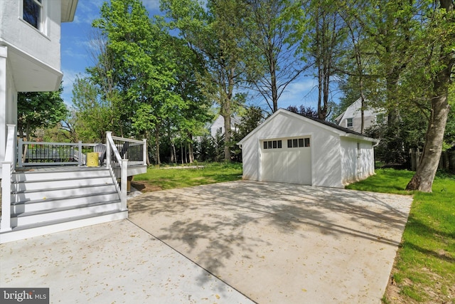 view of patio / terrace with an outbuilding, a garage, and driveway