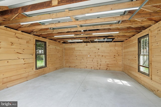 spare room with wood walls and concrete flooring