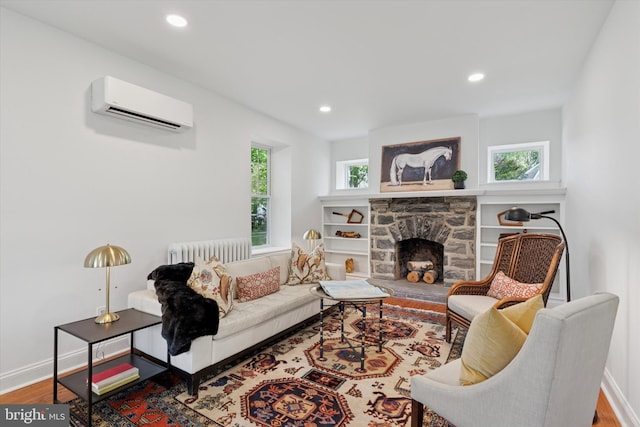living room with an AC wall unit, radiator, wood finished floors, a fireplace, and recessed lighting