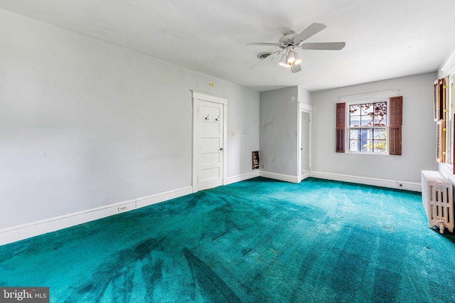 carpeted spare room featuring radiator heating unit, a ceiling fan, and baseboards