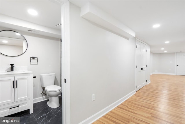 2312 Edmondson Ave, Baltimore, MD 21223 - bathroom with baseboards, toilet, recessed lighting, vanity, and wood finished floors