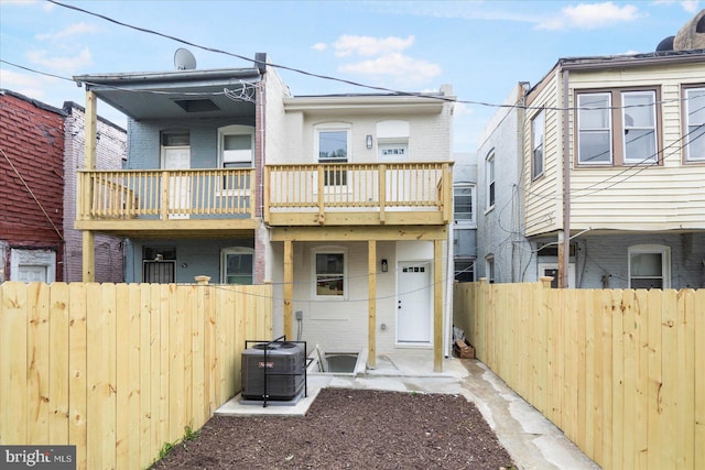 2312 Edmondson Ave, Baltimore, MD 21223 - back of house featuring brick siding, fence, cooling unit, and a balcony