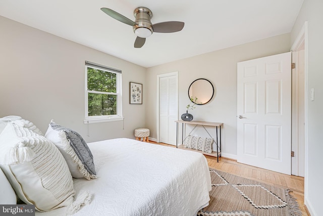 bedroom with wood finished floors, baseboards, a ceiling fan, and a closet