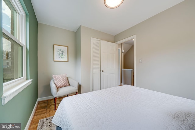 bedroom featuring wood finished floors, baseboards, and multiple windows