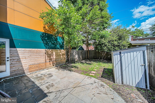 view of patio / terrace with a storage shed, a fenced backyard, and an outdoor structure