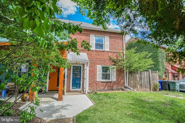 view of front of home with brick siding and a patio