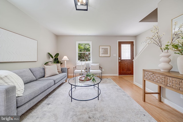 living room with light wood-type flooring, healthy amount of natural light, and baseboards
