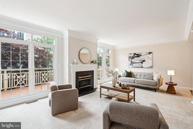 carpeted living room with ornamental molding, plenty of natural light, a fireplace with flush hearth, and baseboards