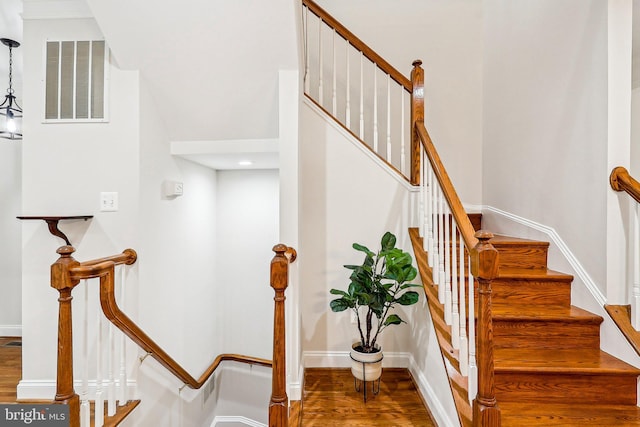 staircase with wood finished floors and baseboards