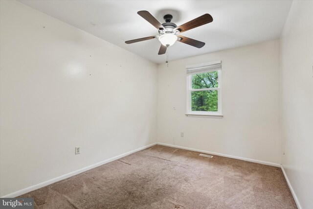 carpeted empty room with baseboards and ceiling fan
