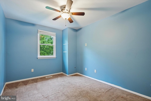 carpeted empty room featuring ceiling fan and baseboards