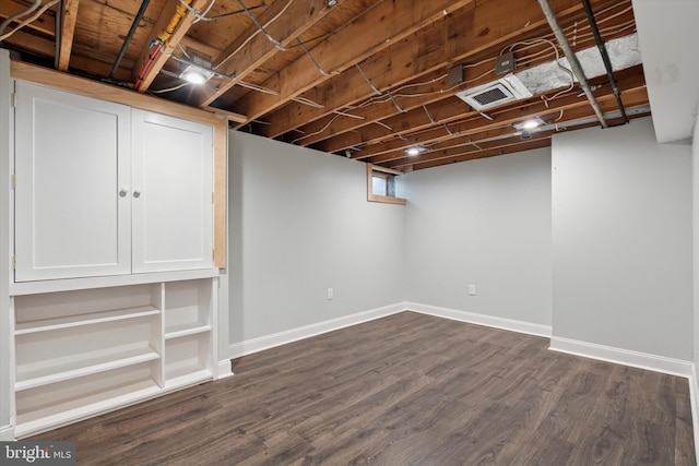 below grade area featuring baseboards and dark wood-style flooring