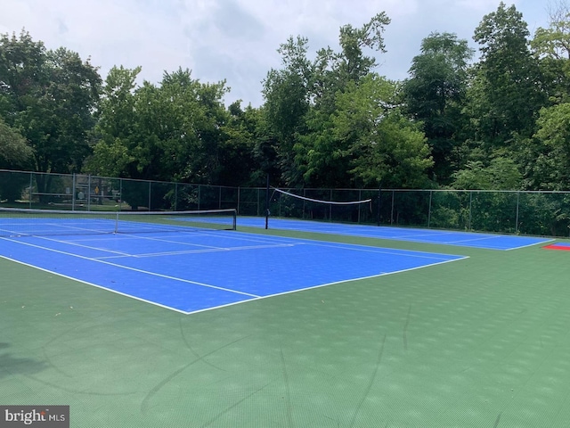 view of tennis court with fence and community basketball court