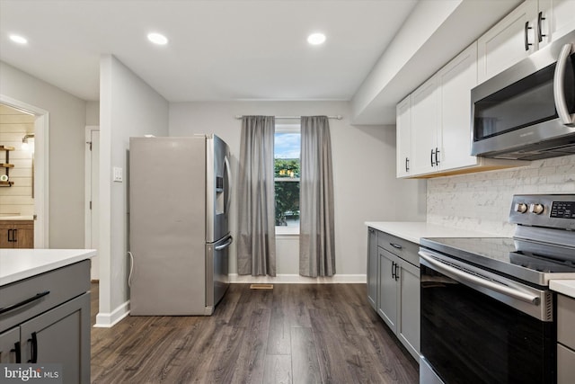 kitchen featuring appliances with stainless steel finishes, gray cabinets, light countertops, dark wood-type flooring, and recessed lighting