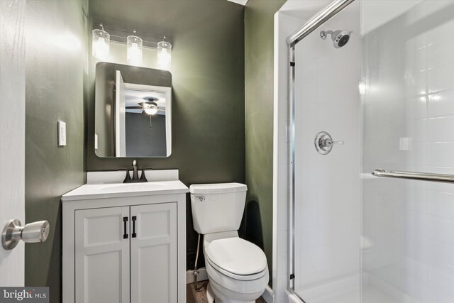 full bathroom with a shower stall, toilet, vanity, and a ceiling fan