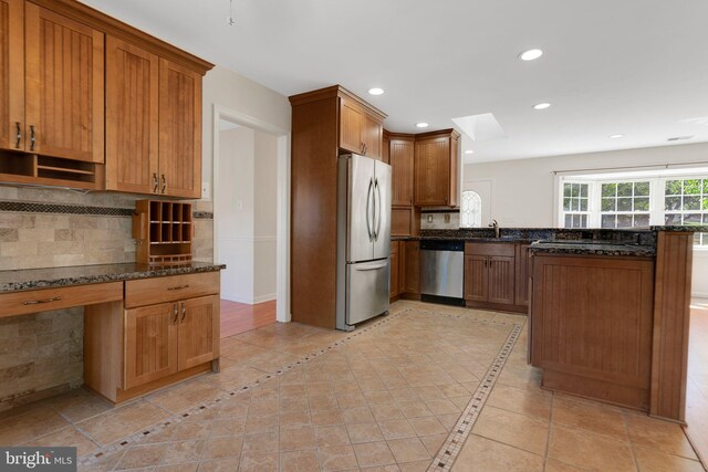 1711 Tedbury St, Crofton, MD 21114 - kitchen with appliances with stainless steel finishes, a sink, a peninsula, dark stone countertops, and tasteful backsplash