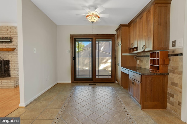 1711 Tedbury St, Crofton, MD 21114 - doorway to outside featuring ceiling fan, baseboards, and a brick fireplace
