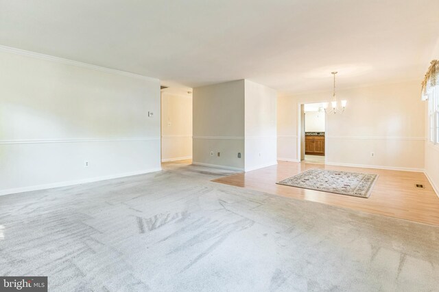 1711 Tedbury St, Crofton, MD 21114 - unfurnished room with a chandelier, baseboards, carpet, and crown molding