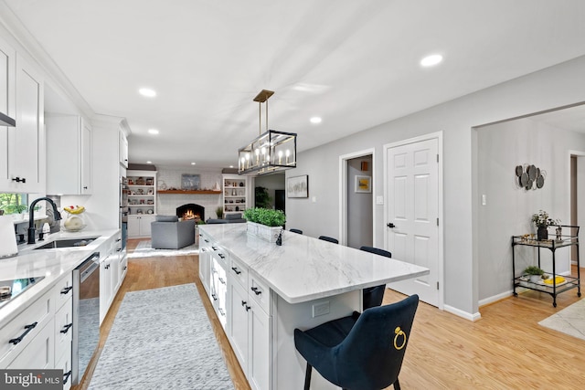 15807 Marlington Dr, Dumfries, VA 22025 - kitchen featuring a sink, a brick fireplace, open floor plan, white cabinets, and stainless steel dishwasher