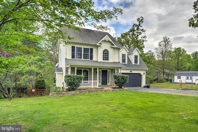 view of front of house featuring a porch, aphalt driveway, roof with shingles, an attached garage, and a front lawn