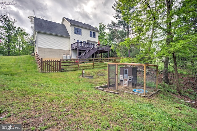 view of yard featuring a deck, exterior structure, and fence